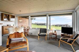 a living room with chairs and a television and windows at LF880-Snedsted-Over-Reese-11 in Snedsted