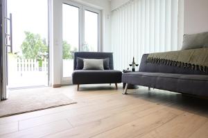 a living room with a couch and a chair at Modernes Ferienhäuschen am Zeulenrodaer Meer mit Terrasse, Klimaanlage, 1 SZ, max 3 Gäste in Zeulenroda +30 photos