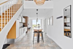 a kitchen and dining room with a table and a staircase at 1160-Romo-Gulirisvej-160 in Høm
