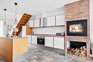 a kitchen with a fireplace and a stove at 1160-Romo-Gulirisvej-160 in Høm +20 photos