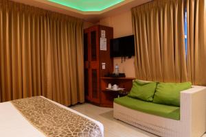 a room with a bed and a couch and a television at Six In Lodge in Male City