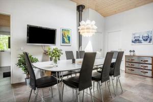 a dining room with a white table and black chairs at LF271-Vestervig-Gunhildsvej-49 in Vestervig