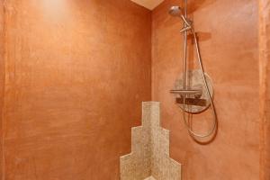 a shower in a bathroom with a wall at Dordinaire Maison D'hôtes in Nouans-les-Fontaines