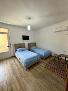 a bedroom with two beds and a television in it at Appartments Kristi&Iris in Vlorë