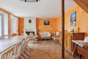 a dining room with a table and chairs and a fireplace at Le Café de l'Encloître in Beaumont-la-Ronce