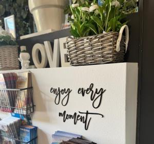 a sign that sayslove every mom end on a shelf with plants at Regina Urban Beach Hotel in Lido di Jesolo