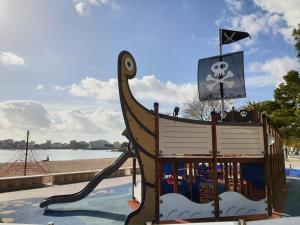 a playground with a wooden rocking chair with a pirate sign at Suites ROC Portonova - Newly Renovated 2026 in Palmanova