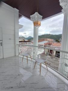 a balcony with two chairs and a chandelier at Detara Homestay Syariah in Takengon