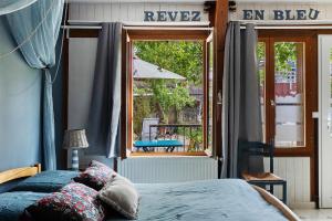 a bedroom with a bed and a view of a patio at Dordinaire Maison D'hôtes in Nouans-les-Fontaines
