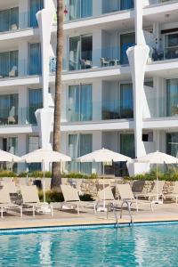 a pool with chairs and umbrellas next to a building at Suites ROC Portonova - Newly Renovated 2026 in Palmanova +45 photos