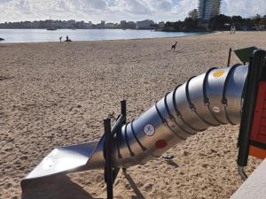 a telescope on a beach with people in the background at Suites ROC Portonova - Newly Renovated 2026 in Palmanova