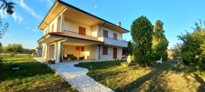 a large white house with a grass yard at Il Falcineto in Pesaro
