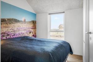 a bedroom with a bed with a painting on the wall at 394-Harboore-Hermodsvej-8 in Harboør