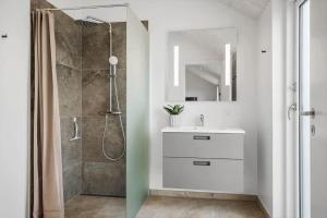 a bathroom with a white sink and a shower at 394-Harboore-Hermodsvej-8 in Harboør +24 photos