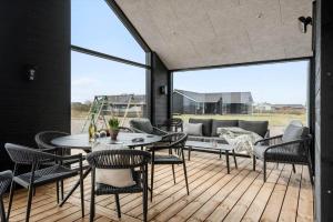 a patio with a table and chairs and a couch at 394-Harboore-Hermodsvej-8 in Harboør