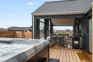 a patio with a hot tub on a deck at 394-Harboore-Hermodsvej-8 in Harboør