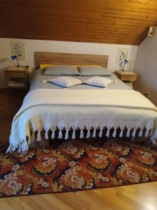 a bedroom with a large bed with a rug at Popas Făgărășan in Făgăraş