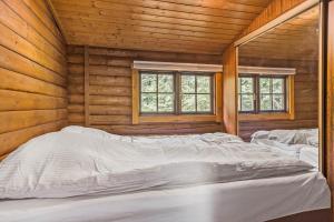 a bedroom with three beds in a wooden cabin at LF14362-Roslev-Nautrupvej-62 in Roslev