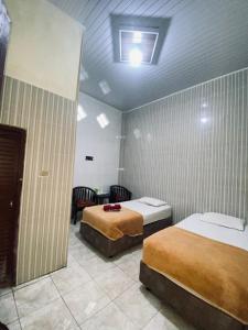 a hotel room with two beds and a window at Detara Homestay Syariah in Takengon