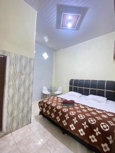 a bedroom with a bed and a table in a room at Detara Homestay Syariah in Takengon