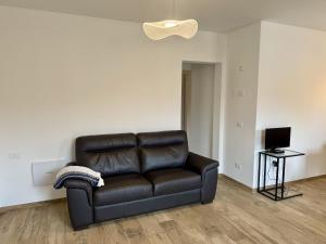 ein schwarzes Ledersofa im Wohnzimmer in der Unterkunft Feder Peaks in Canale dʼAgordo