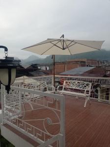 a white umbrella sitting on top of a deck at Detara Homestay Syariah in Takengon