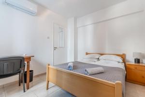 a bedroom with a bed and a desk and a tv at Andreas Beachfront Hostel in Larnaca +22 photos