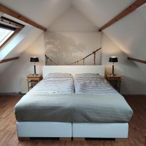 a bed in a room with two lamps on two tables at Logies op Dreef in Driebergen