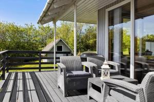 a patio with wicker chairs and tables on a porch at LF14092-Roslev-Eskovvej-92 in Roslev