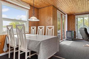 a dining room with a table and chairs and windows at LF14092-Roslev-Eskovvej-92 in Roslev