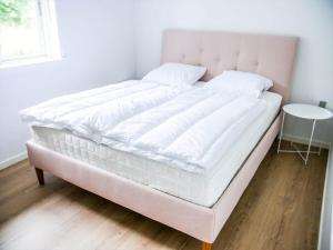 a bed with a white mattress and a table at 16655-Farevejle-Truntebakken-4 in Fårevejle