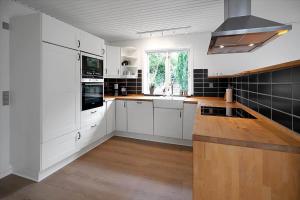 a kitchen with white cabinets and a wooden counter top at 16655-Farevejle-Truntebakken-4 in Fårevejle