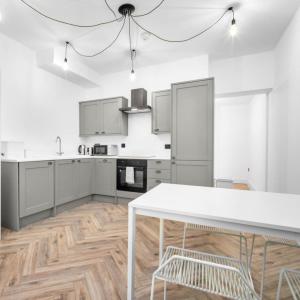 a kitchen with white cabinets and a white table at Modern 3 Bed Townhouse - Wolverhampton Centre - Gated Development - Bedroom TV 1CO in Wolverhampton