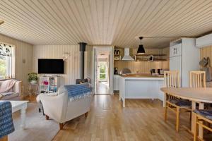 a living room with a table and a kitchen at LF16021-Farso-Kjeldhoj-121 in Farsø