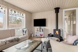 a living room with a couch and a fireplace at LF16021-Farso-Kjeldhoj-121 in Farsø