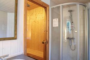 a bathroom with a shower and a wooden door at 10055-1-Rorvig-Lindevangen-4 in Rørvig +24 photos
