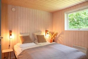 a bedroom with a large bed with a window at 10055-1-Rorvig-Lindevangen-4 in Rørvig