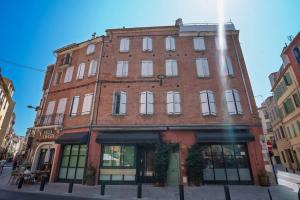an old red brick building on a city street at Le cocoon de Pome et Leon in Perpignan