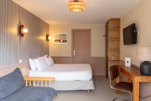 a hotel room with a bed and a couch at Hôtel Restaurant Bellevue in Bréhat