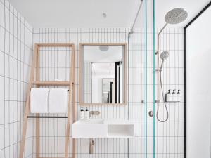 a bathroom with a shower and a sink and a mirror at Little National Hotel Adelaide in Adelaide +31 photos