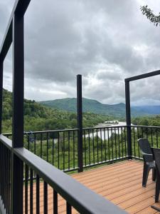 a balcony with chairs and a view of the mountains at Helios racha in Ambrolauri