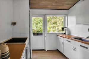 a kitchen with white cabinets and a window at 18008-Holbaek-Raevestien-5 in Holbæk