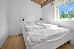 a white bed in a room with a window at 18008-Holbaek-Raevestien-5 in Holbæk