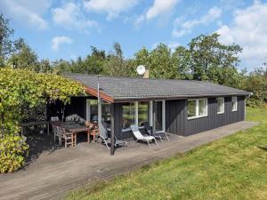 a black shed with a deck and a table and chairs at 18008-Holbaek-Raevestien-5 in Holbæk +12 photos