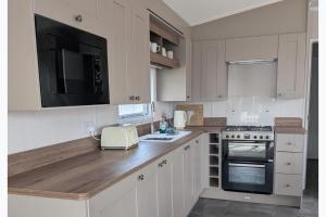 a kitchen with white cabinets and a counter top at Seaside Haven Hunstanton 2026 Model in Hunstanton