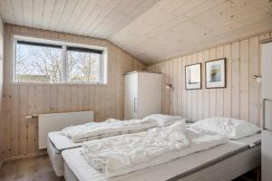 a bedroom with two beds in a room with a window at 0259-Romo-Lyngvejen-89-B in Høm