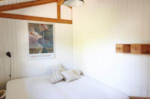 a bedroom with a white bed and a picture on the wall at 13405-1-Hojby-Avaenget-1 in Højby