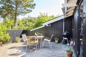 a patio with a table and chairs and a grill at 13405-1-Hojby-Avaenget-1 in Højby