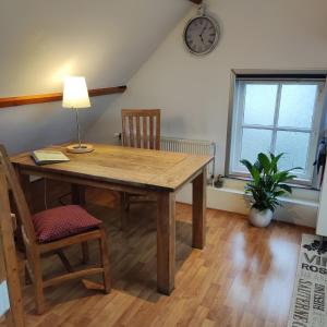 a dining room table with chairs and a clock on the wall at Logies op Dreef in Driebergen +6 photos