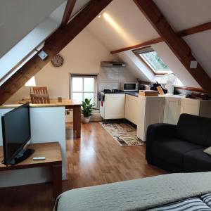 a living room with a couch and a kitchen at Logies op Dreef in Driebergen